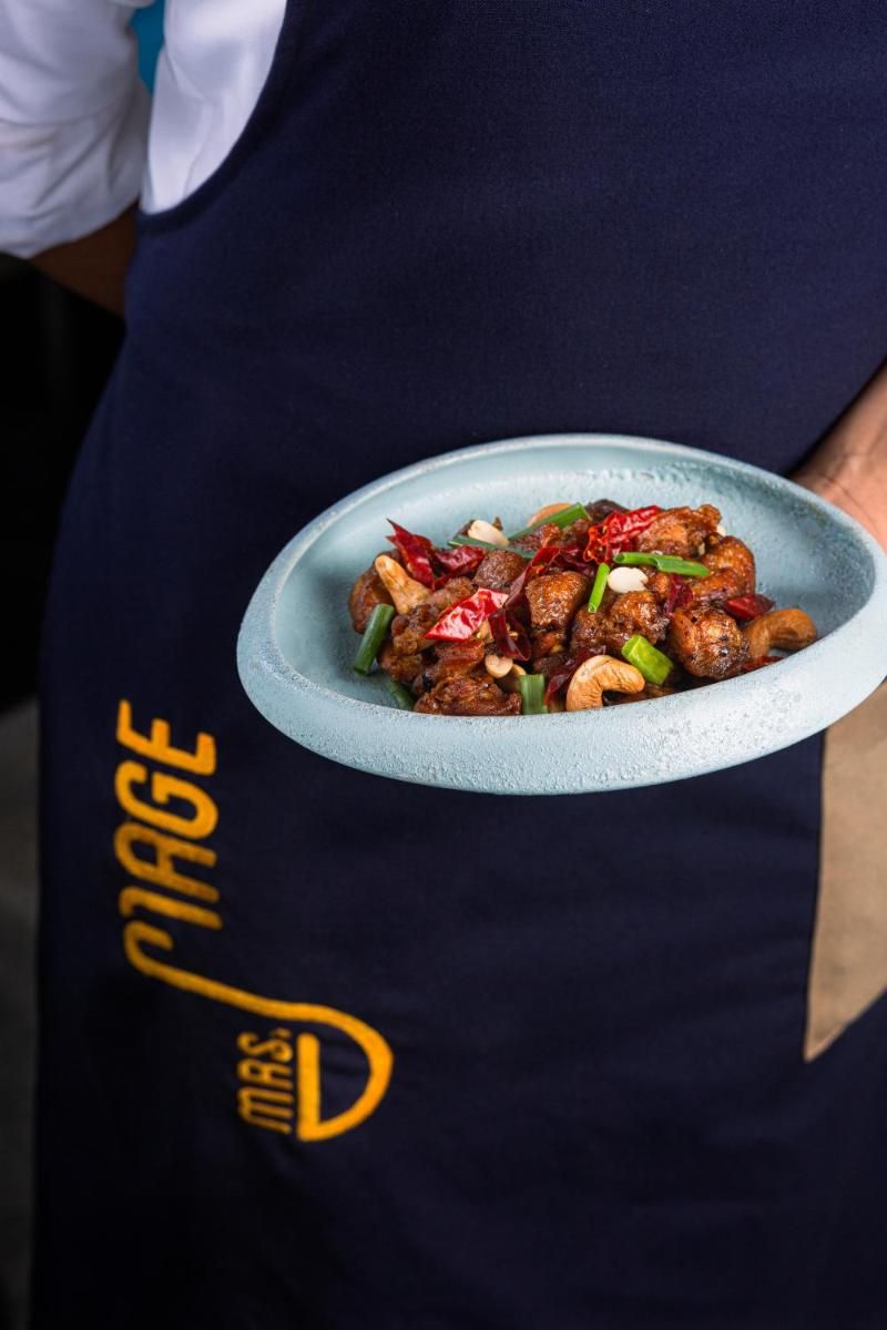 a person holding a plate of food on apron at Hyatt Hyderabad Gachibowli in Hyderabad