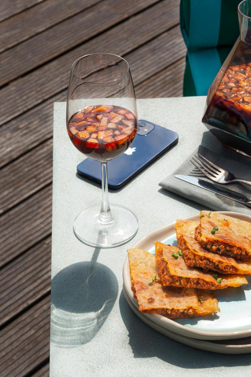 a glass of wine and a plate of food on a table at Hyatt Hyderabad Gachibowli in Hyderabad