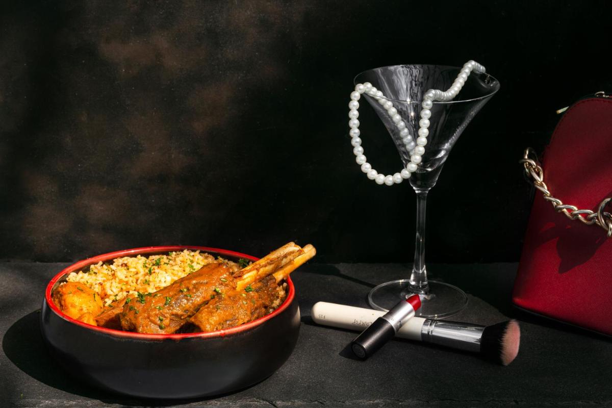 a table with a bowl of food and a glass of wine at Hyatt Hyderabad Gachibowli in Hyderabad