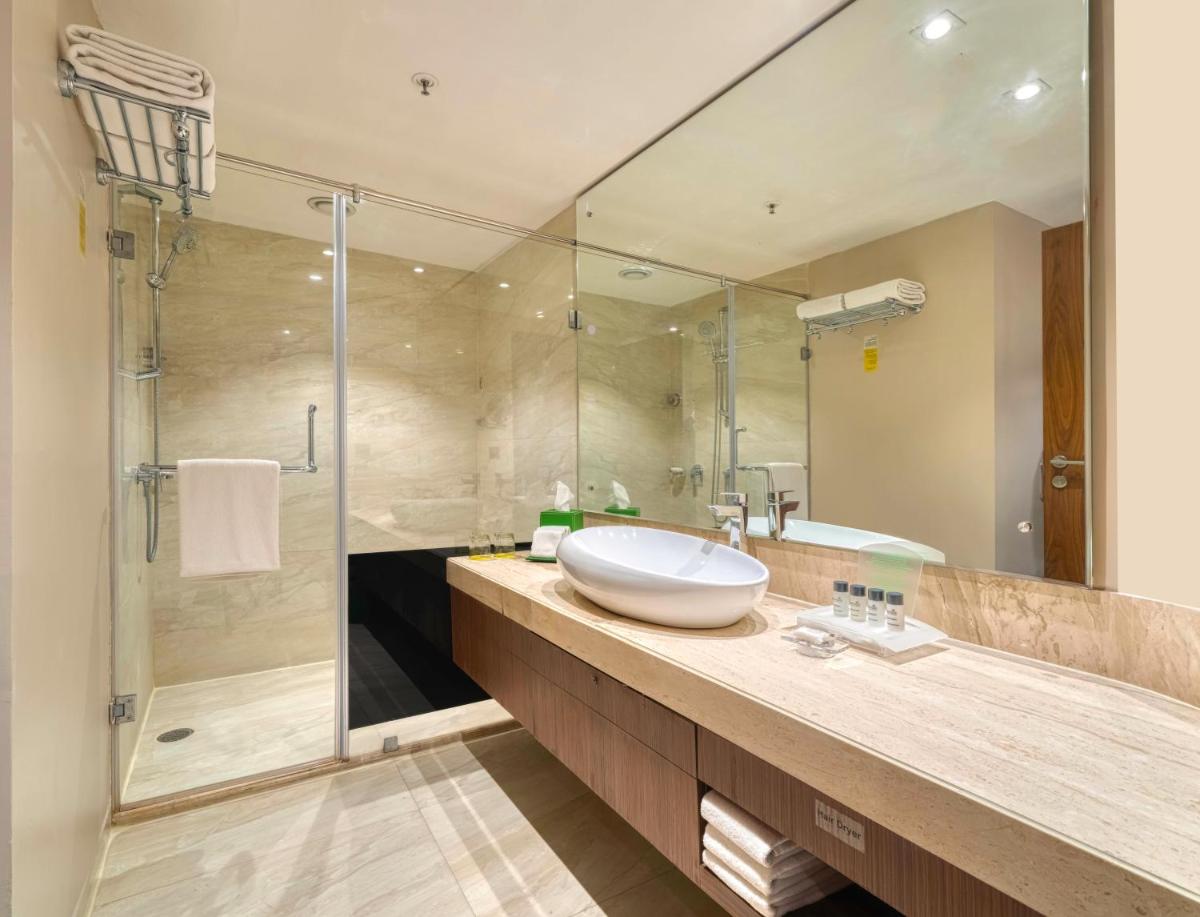 a bathroom with a sink and a shower at Holiday Inn Kolkata Airport by IHG in Kolkata
