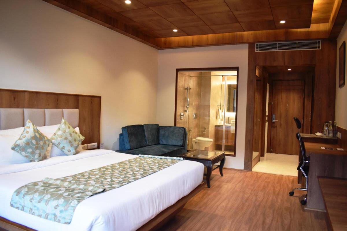 a hotel room with a bed and a chair at The Orchid Manali - a Boutique Hotel in Manāli a hotel room with a bed and a chair at The Orchid Manali - a Boutique Hotel in Manāli