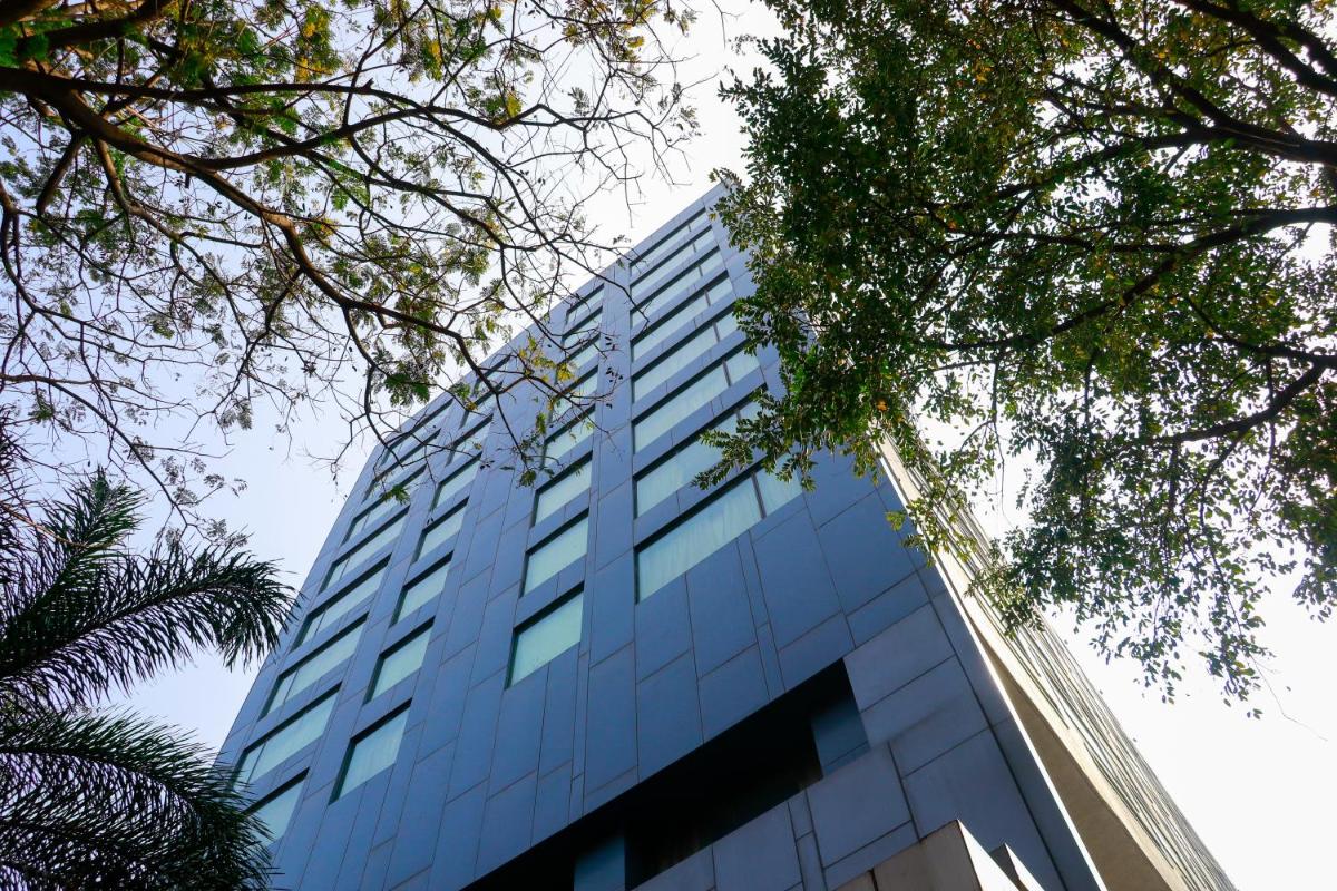 a tall blue building with trees in front of it at Crowne Plaza Pune City Centre by IHG in Pune