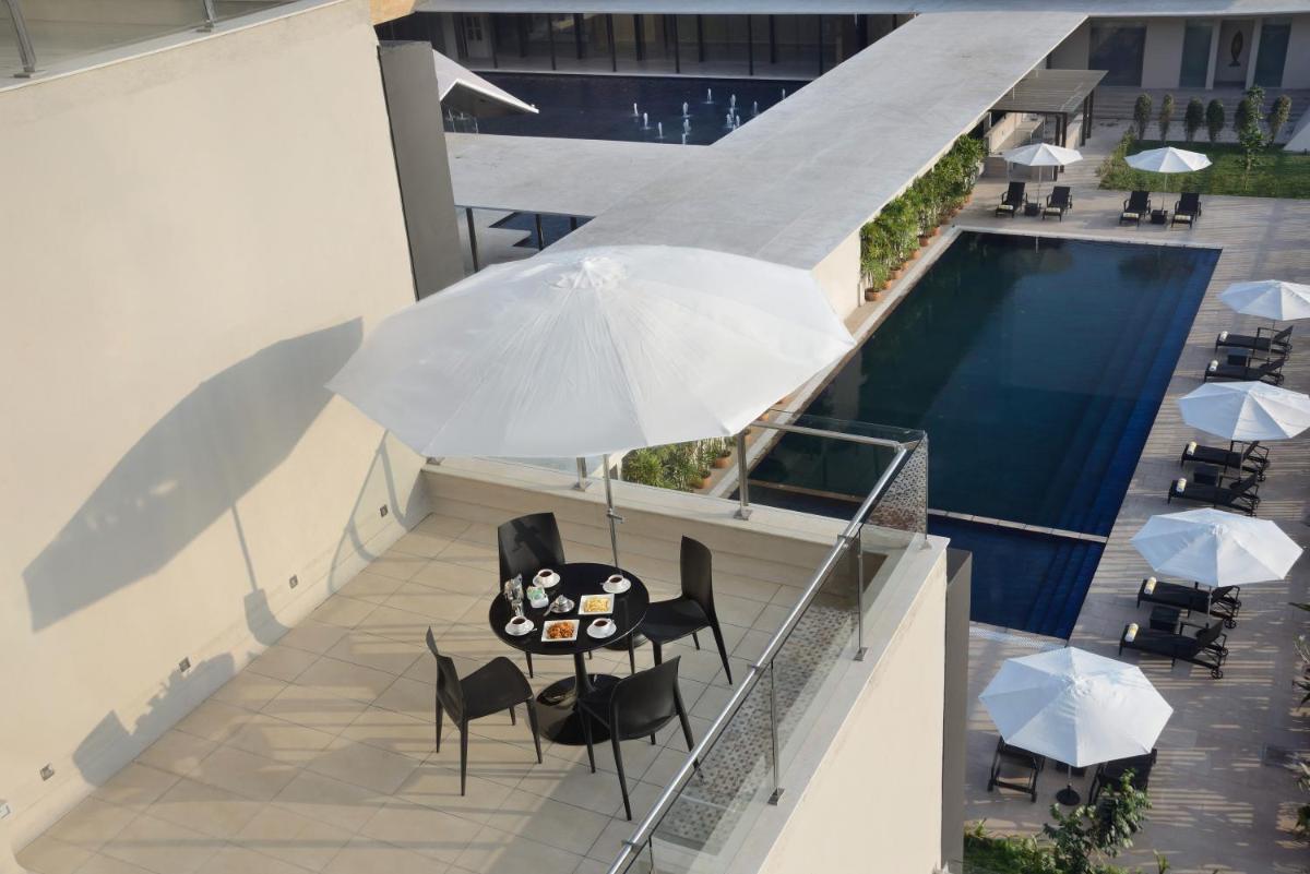 a table and chairs with an umbrella next to a pool at Marasa Sarovar Premiere in Tirupati