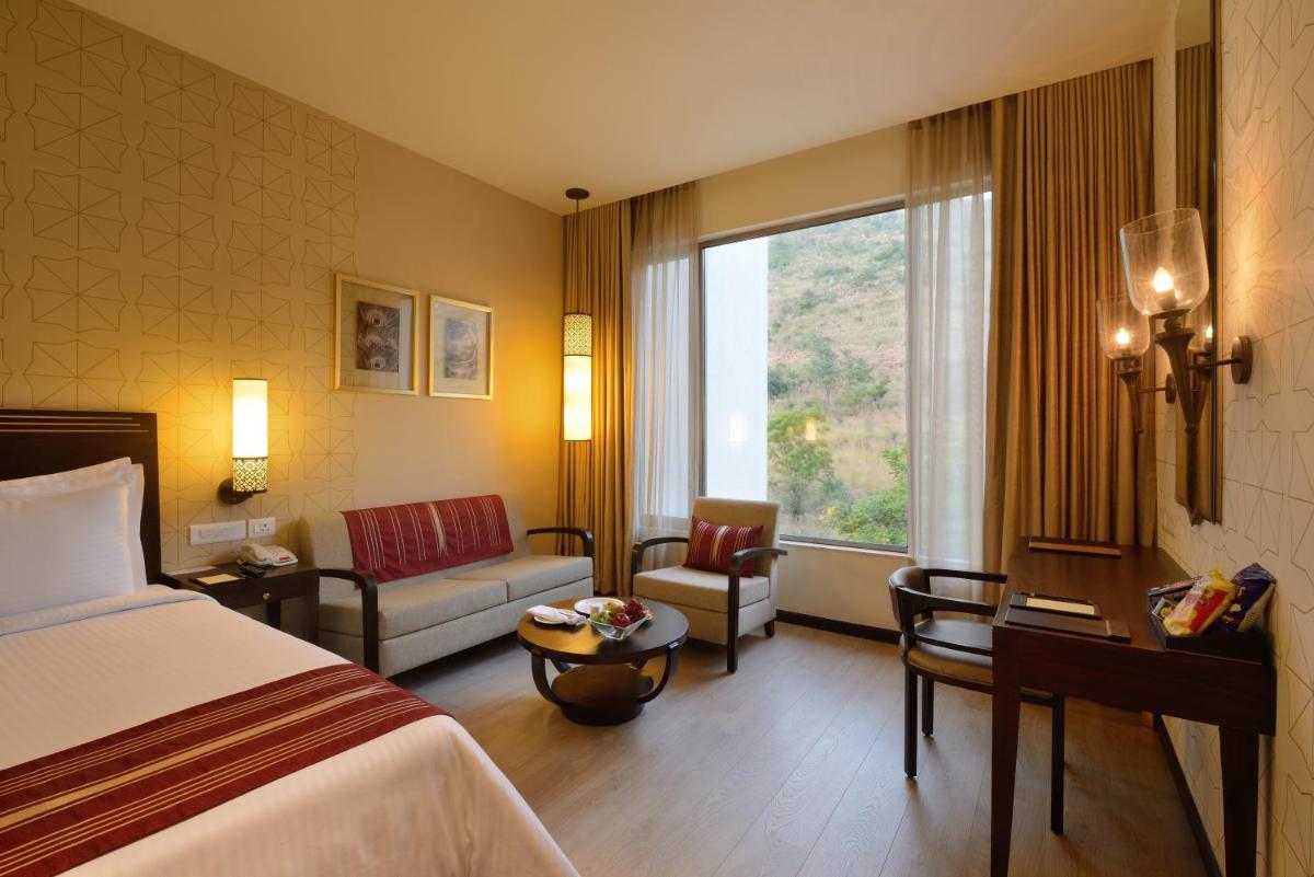 a hotel room with a bed and a window at Marasa Sarovar Premiere in Tirupati