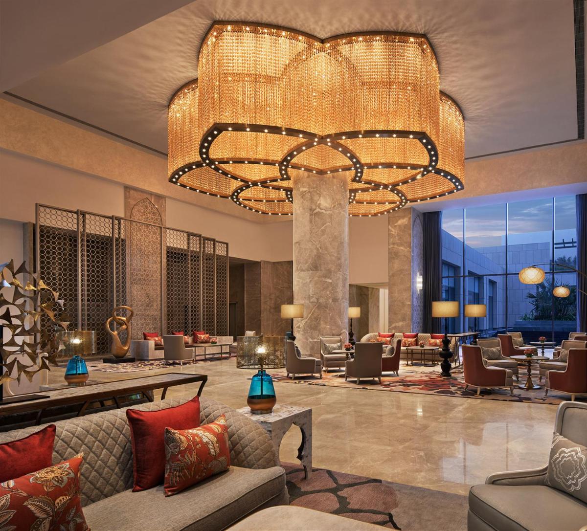 a hotel lobby with a large chandelier at Taj Amer, Jaipur in Jaipur
