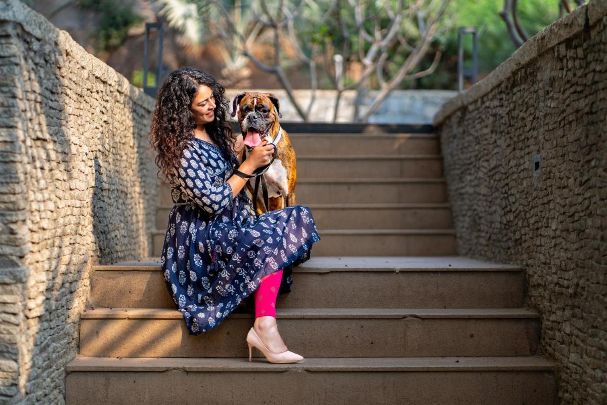 a woman sitting on the stairs with a dog at Hyatt Hyderabad Gachibowli in Hyderabad