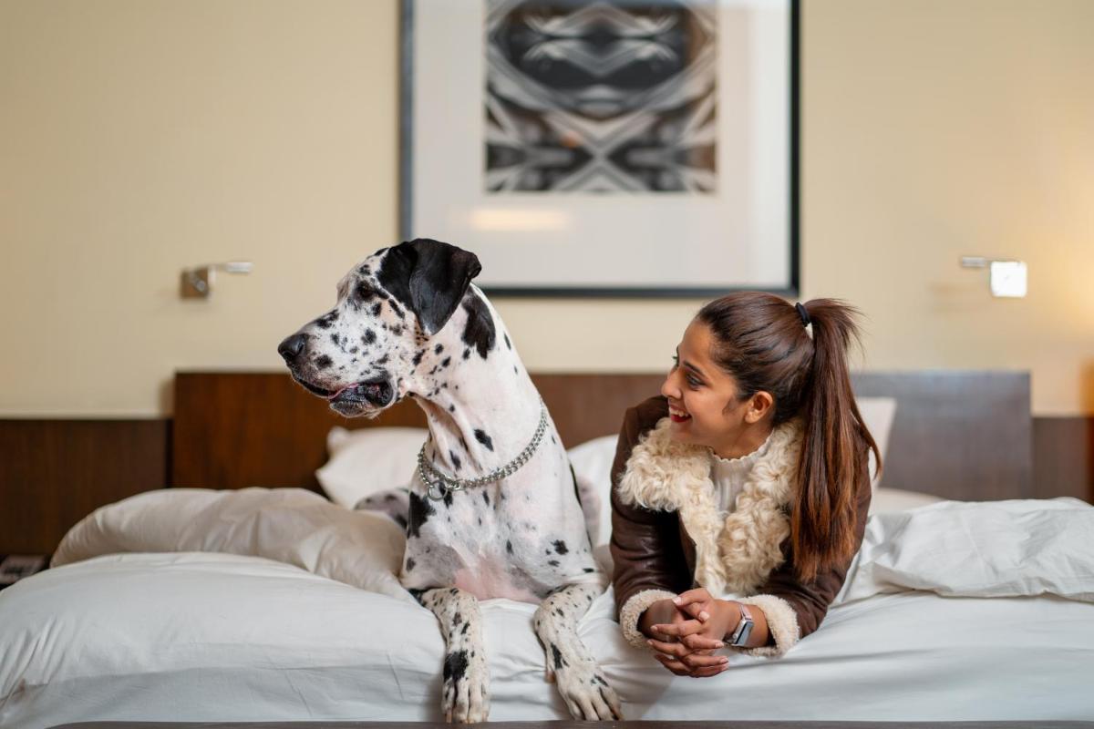 a girl sitting on a bed with a dog at Hyatt Hyderabad Gachibowli in Hyderabad