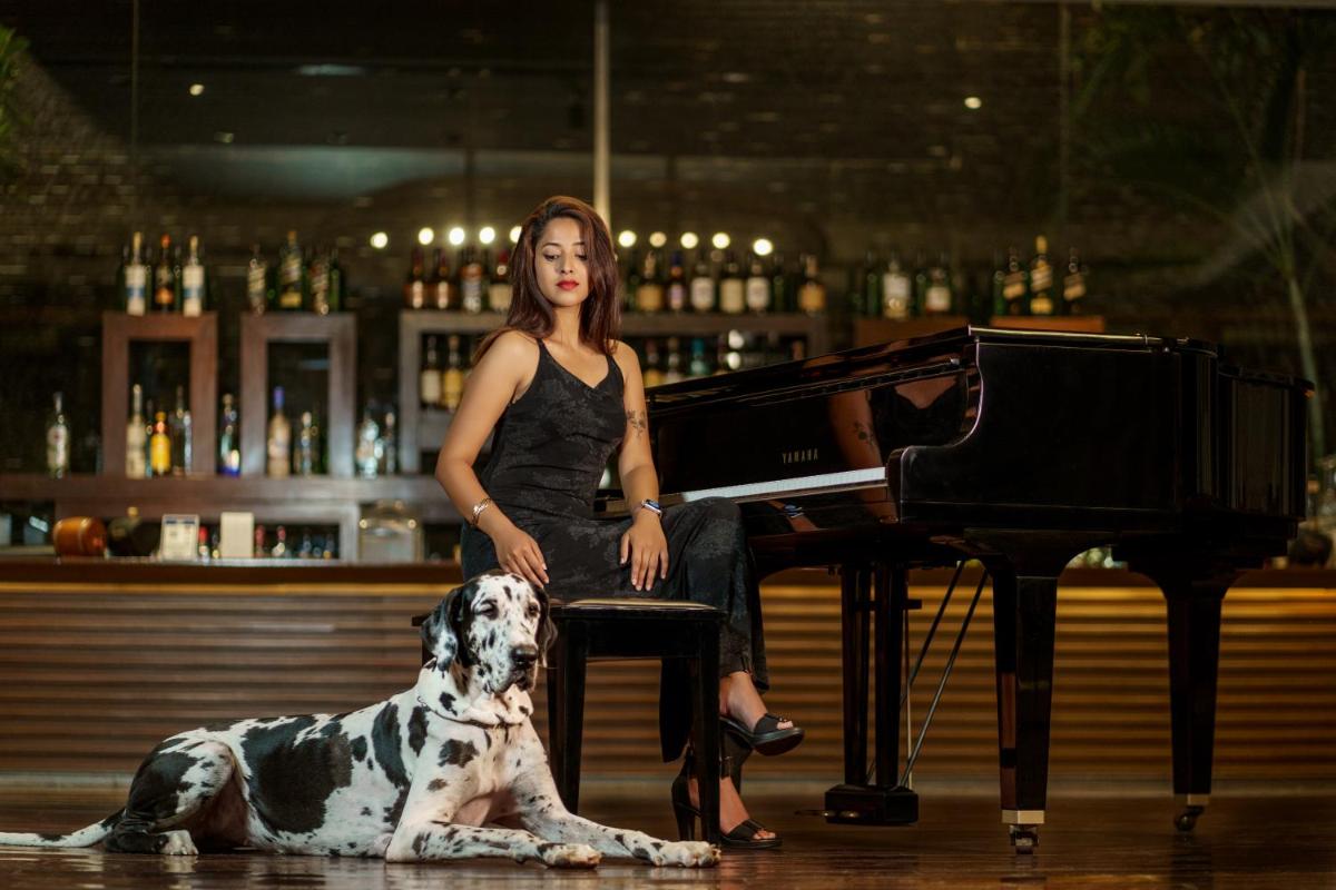 a woman and a dog sitting next to a piano at Hyatt Hyderabad Gachibowli in Hyderabad