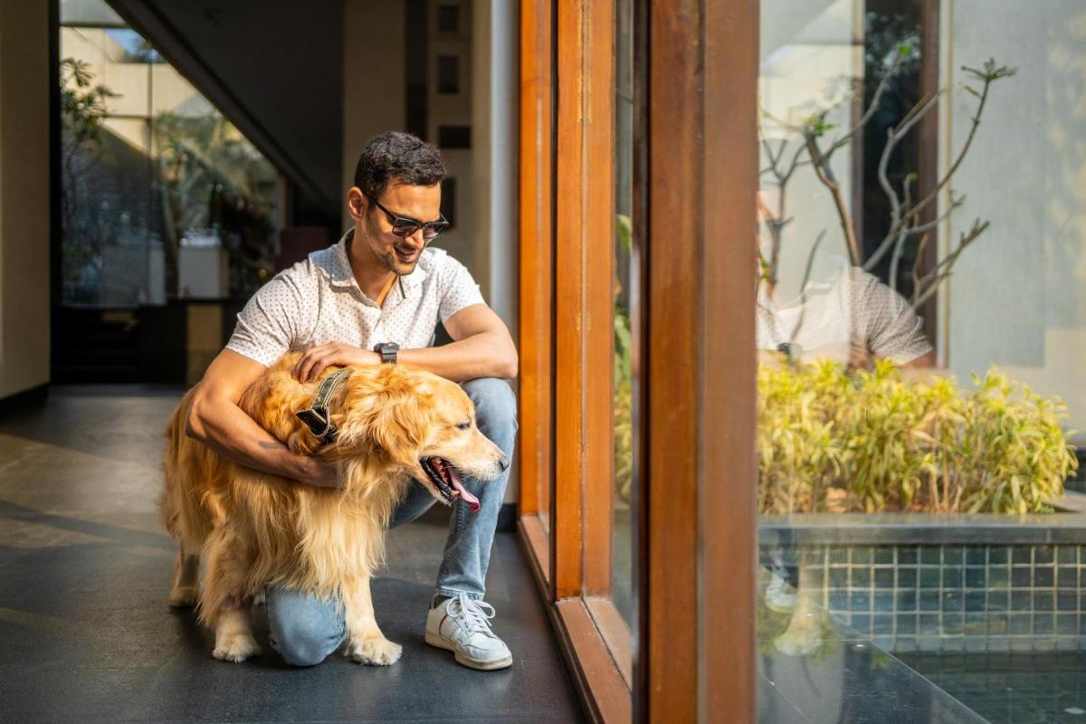 a man sitting with a dog in front of a door at Hyatt Hyderabad Gachibowli in Hyderabad