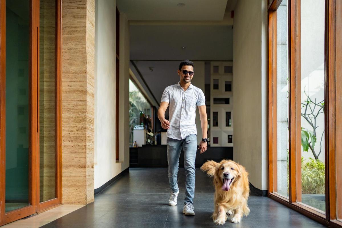 a man walking down a hallway with a dog at Hyatt Hyderabad Gachibowli in Hyderabad