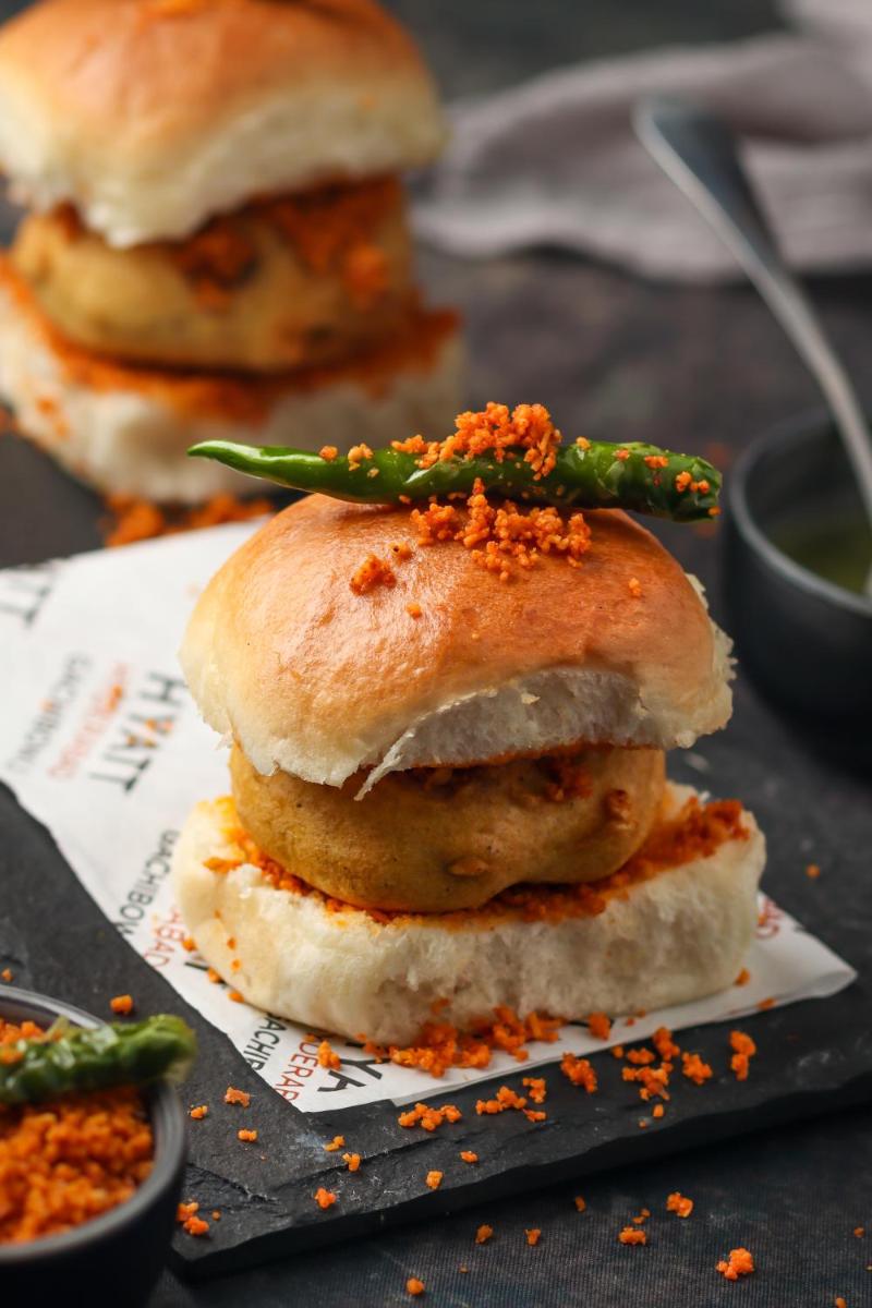 three sandwiches on a plate with green beans on top at Hyatt Hyderabad Gachibowli in Hyderabad