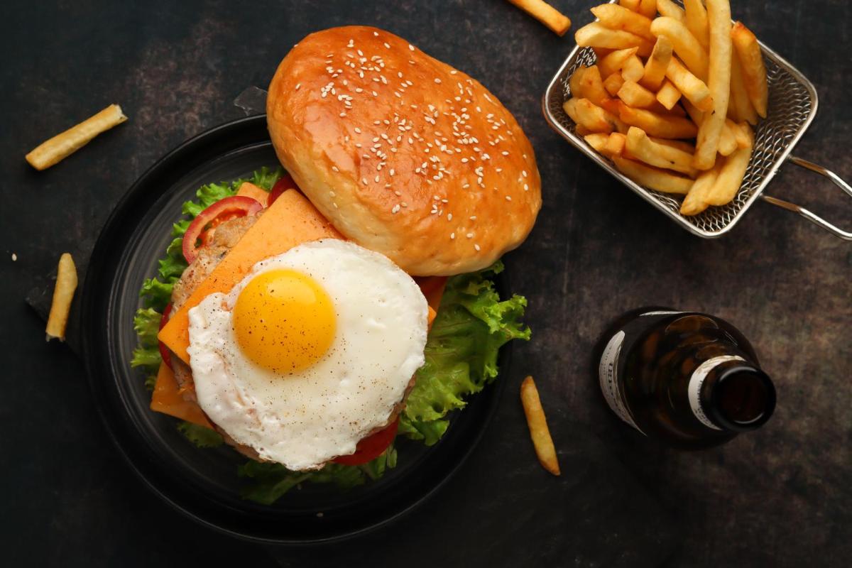 a sandwich with an egg and french fries on a black plate at Hyatt Hyderabad Gachibowli in Hyderabad
