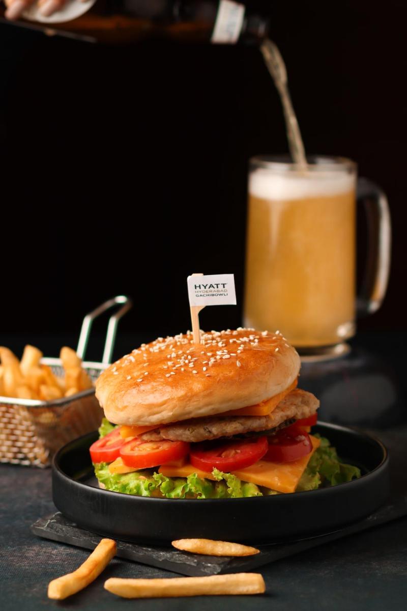 a sandwich on a plate next to a drink at Hyatt Hyderabad Gachibowli in Hyderabad