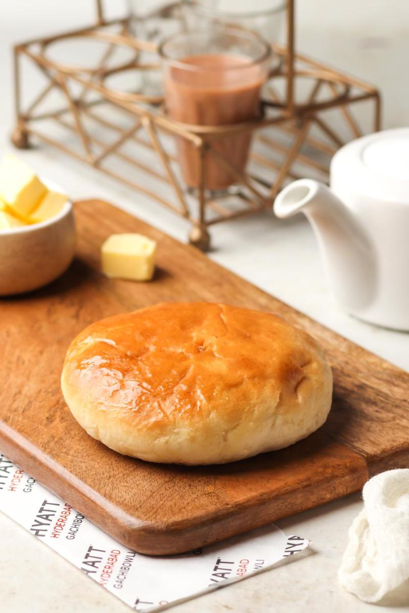 a loaf of bread on a cutting board with butter at Hyatt Hyderabad Gachibowli in Hyderabad