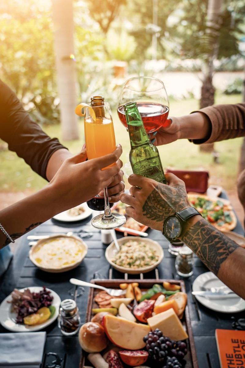 a group of people sitting at a table with food and drinks at Hyatt Hyderabad Gachibowli in Hyderabad
