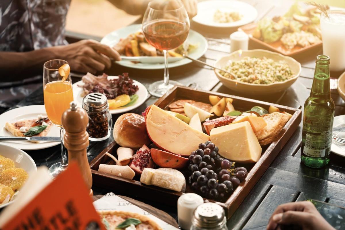 a table topped with plates of food and glasses of wine at Hyatt Hyderabad Gachibowli in Hyderabad