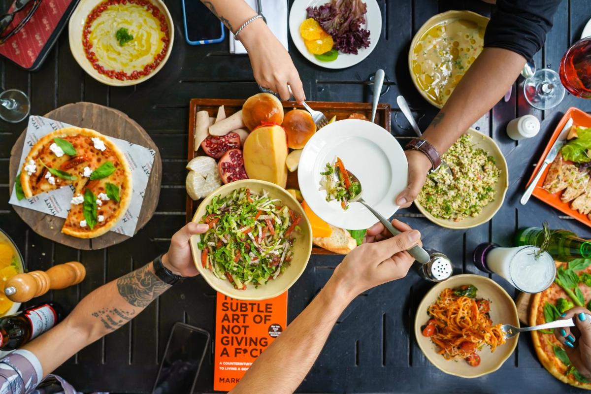 a group of people sitting around a table eating food at Hyatt Hyderabad Gachibowli in Hyderabad