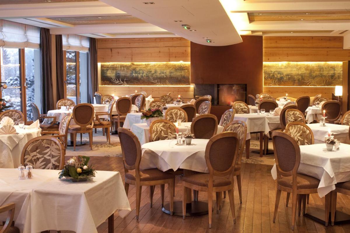 une salle à manger avec des tables et des chaises blanches dans l'établissement Spa Hôtel Restaurant Au Lion d'Or, à La Petite-Pierre