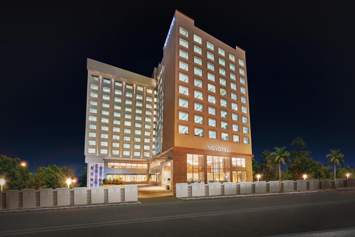 a large hotel building with lights on at night at Novotel Mumbai International Airport in Mumbai