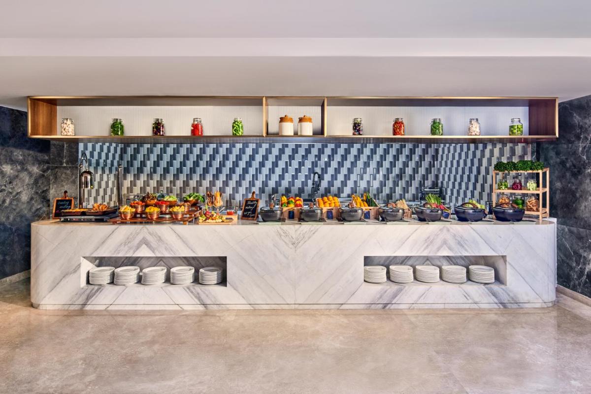 a lobby with a counter with vases on it at Novotel Mumbai International Airport in Mumbai