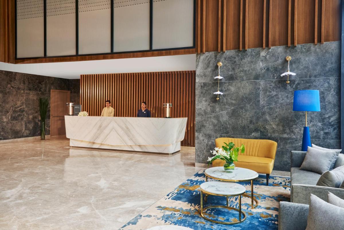 a lobby of a hotel with a reception desk at Novotel Mumbai International Airport in Mumbai