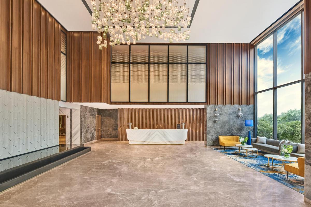 a rendering of a lobby with a table and chairs at Novotel Mumbai International Airport in Mumbai