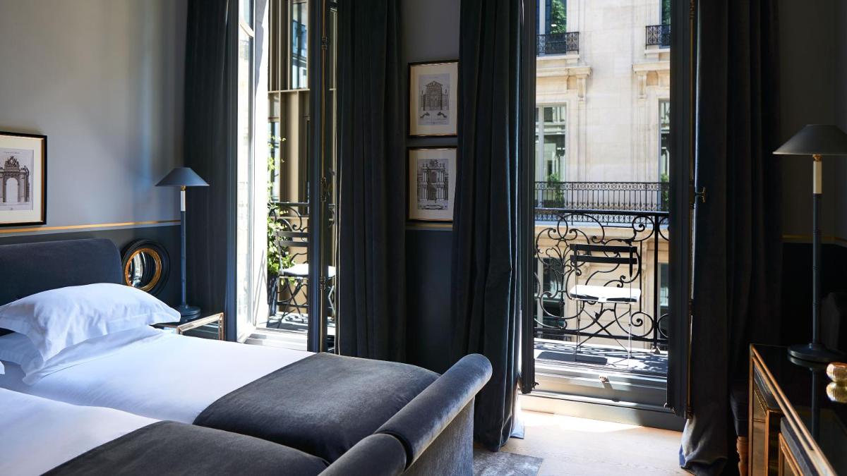 une chambre avec un lit et une grande fenêtre dans l'établissement Monsieur George Hotel & Spa - Champs-Elysées, à Paris