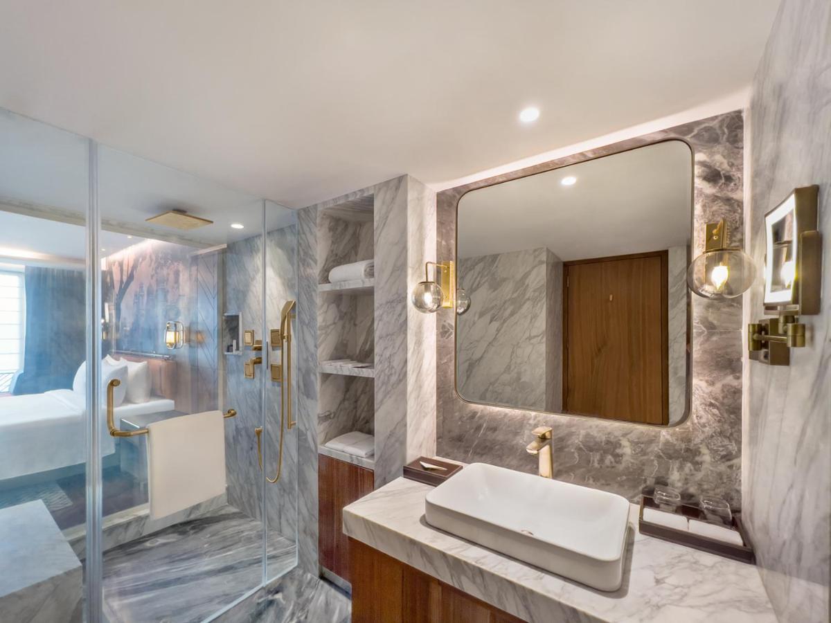 a bathroom with a sink and a shower and a mirror at Radisson Blu Hotel & Suites GRT Chennai in Chennai