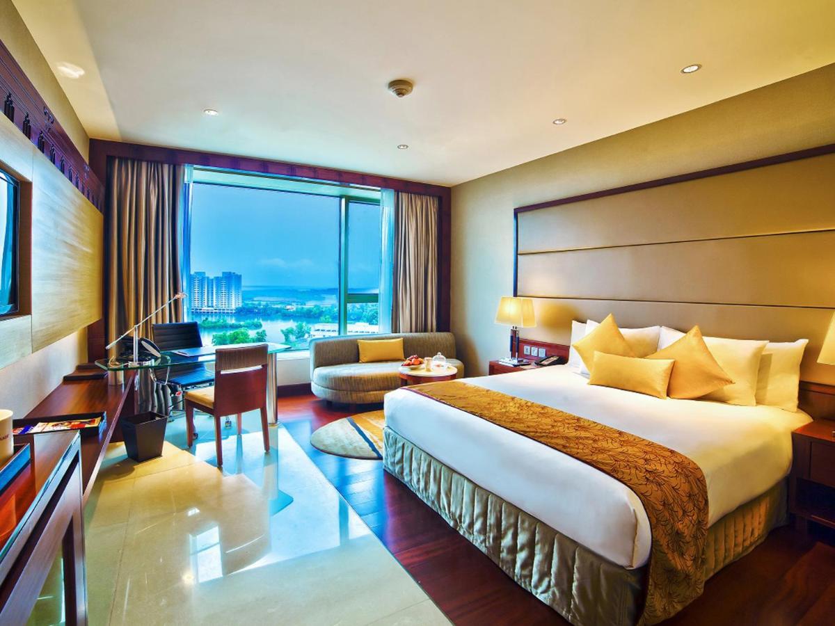 a hotel room with a bed and a large window at Crowne Plaza Kochi by IHG in Cochin