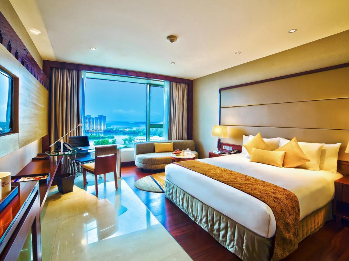 a hotel room with a bed and a large window at Crowne Plaza Kochi by IHG in Cochin