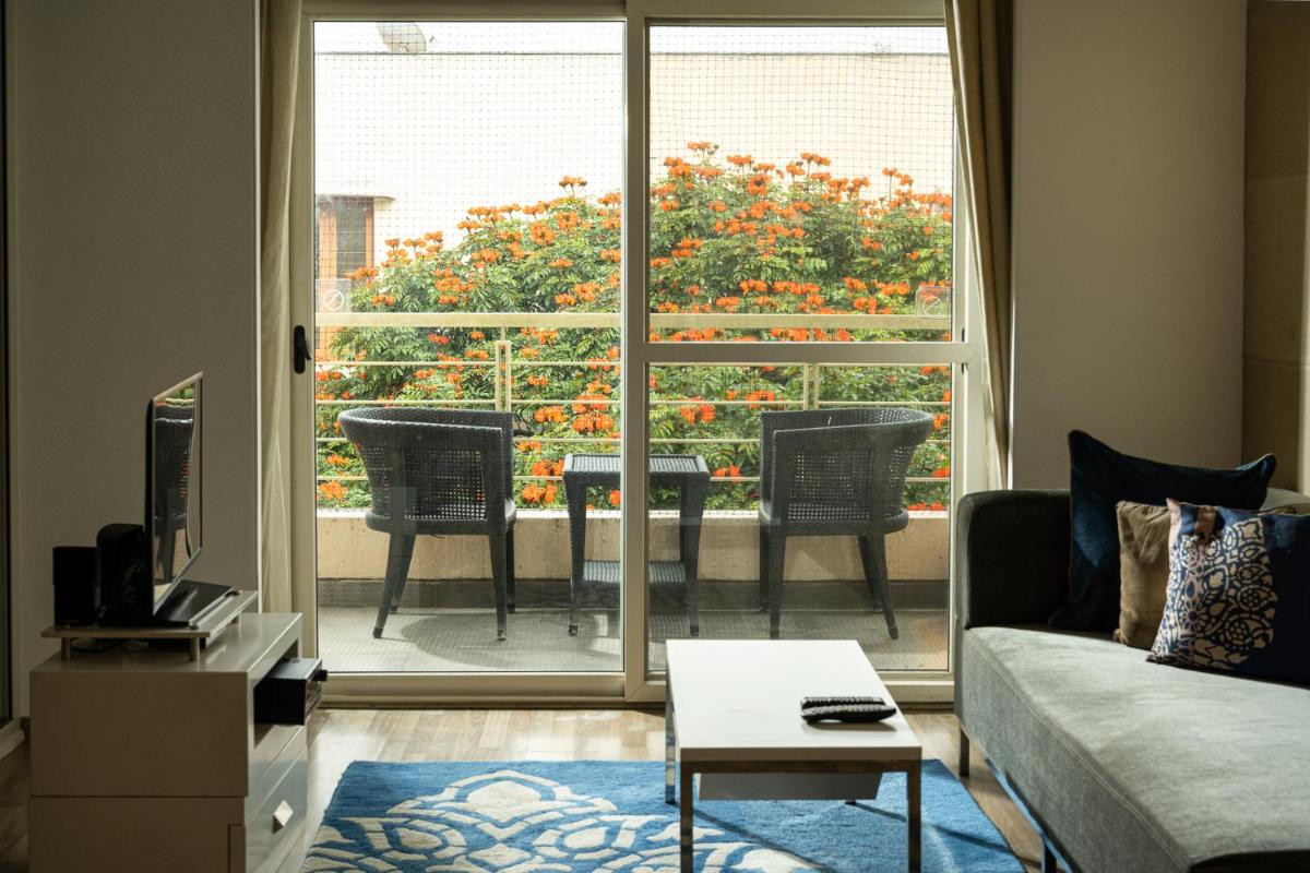a living room with a couch and a view of a patio at Grand Mercure Bangalore - An Accor Brand in Bengaluru