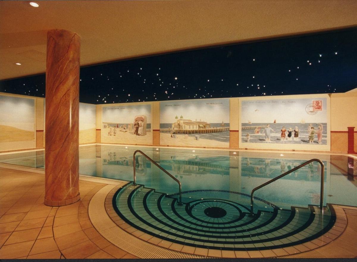 ein Swimmingpool mitten in einem Gebäude in der Unterkunft Usedom Palace in Zinnowitz