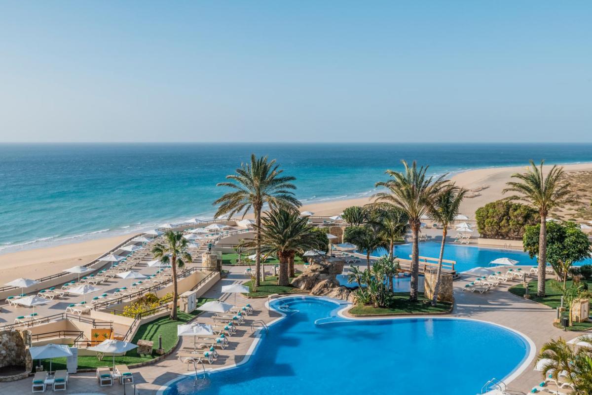 Una vista aérea de un resort con palmeras y la playa. en Iberostar Waves Playa Gaviotas All Inclusive, en Morro del Jable