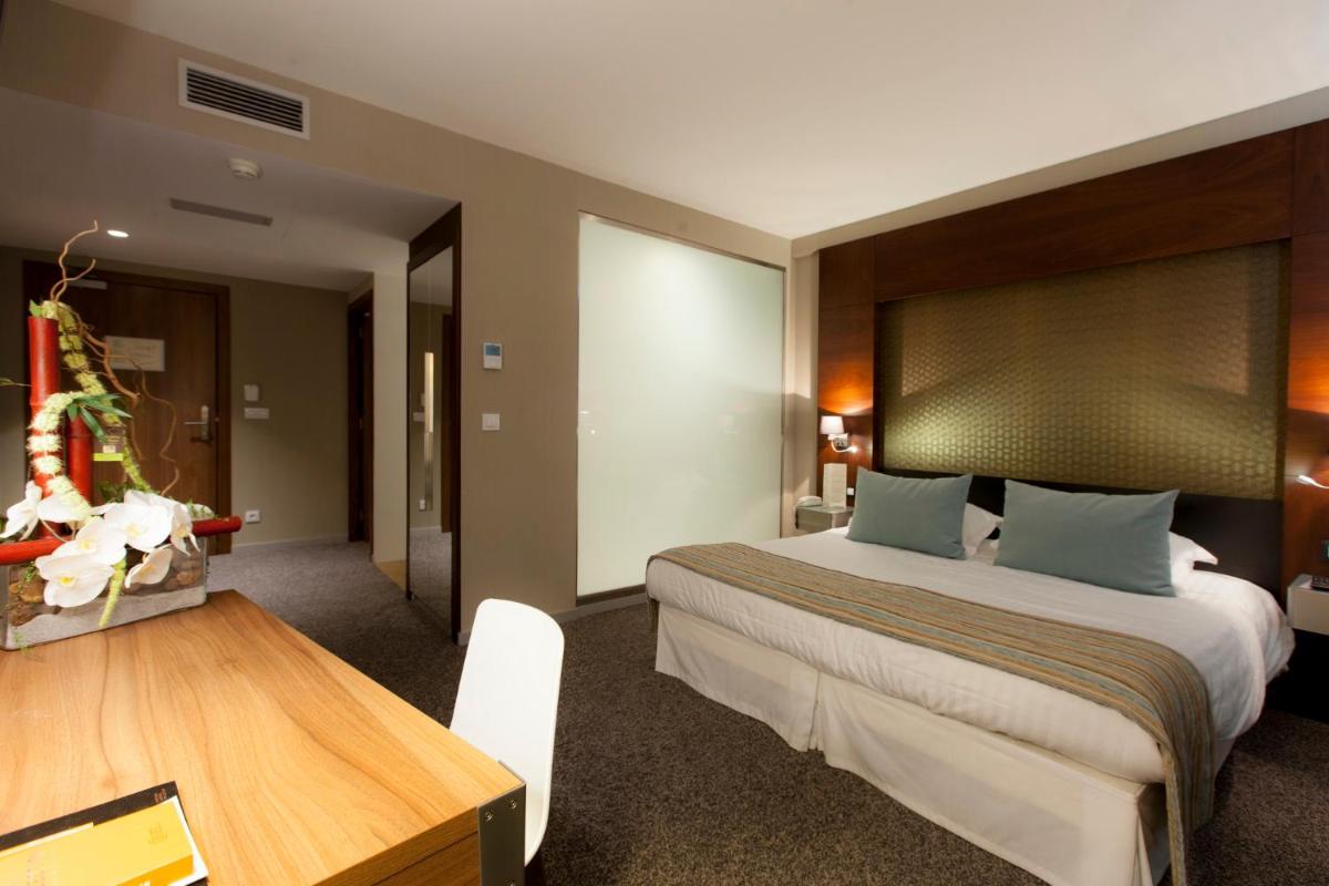 - une chambre avec un grand lit et une table en bois dans l'établissement Alysson Hôtel, à Oloron-Sainte-Marie 29 autres photos