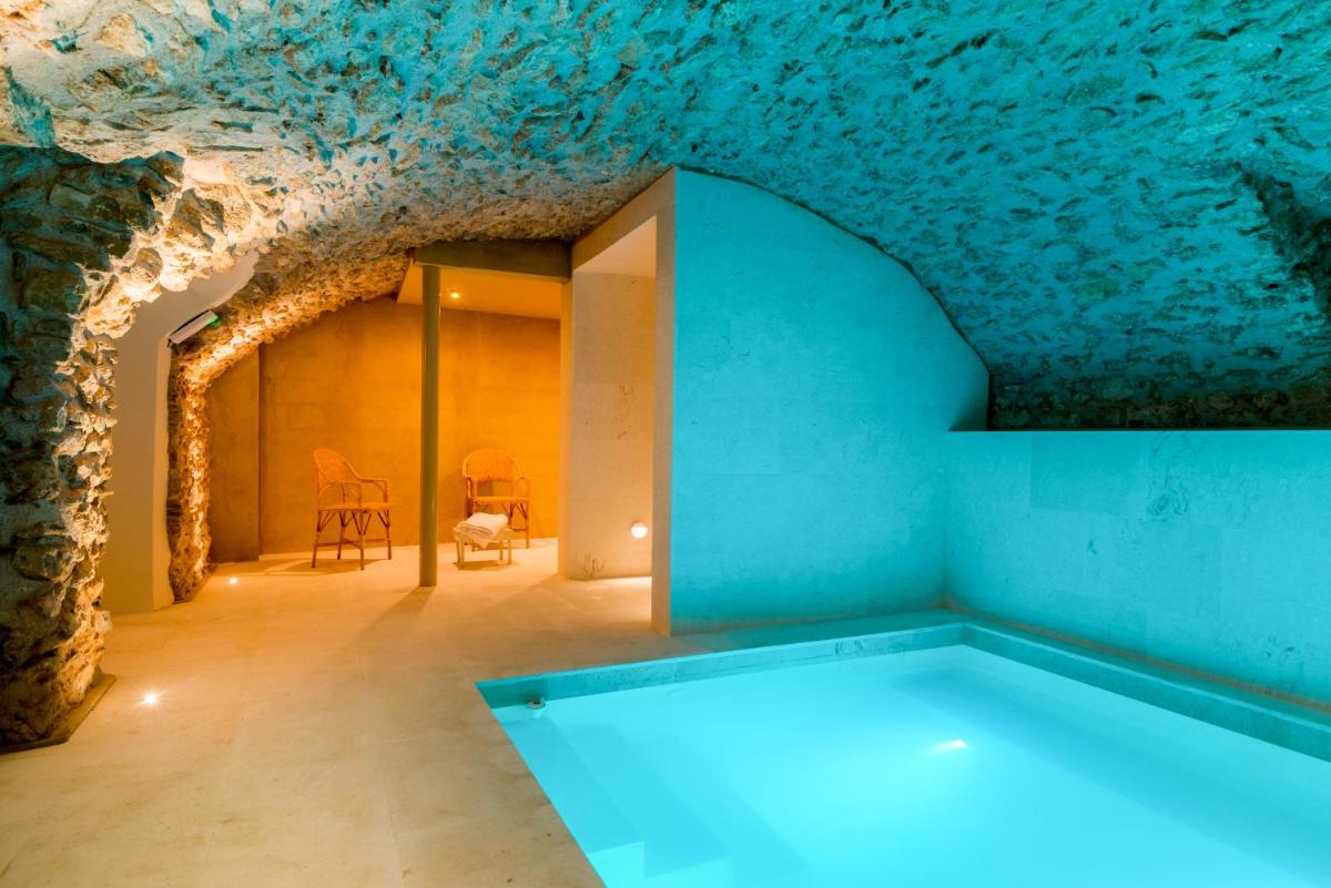 Una habitación con una pared de piedra y un techo azul. en Can Mascort Eco Hotel, en Palafrugell