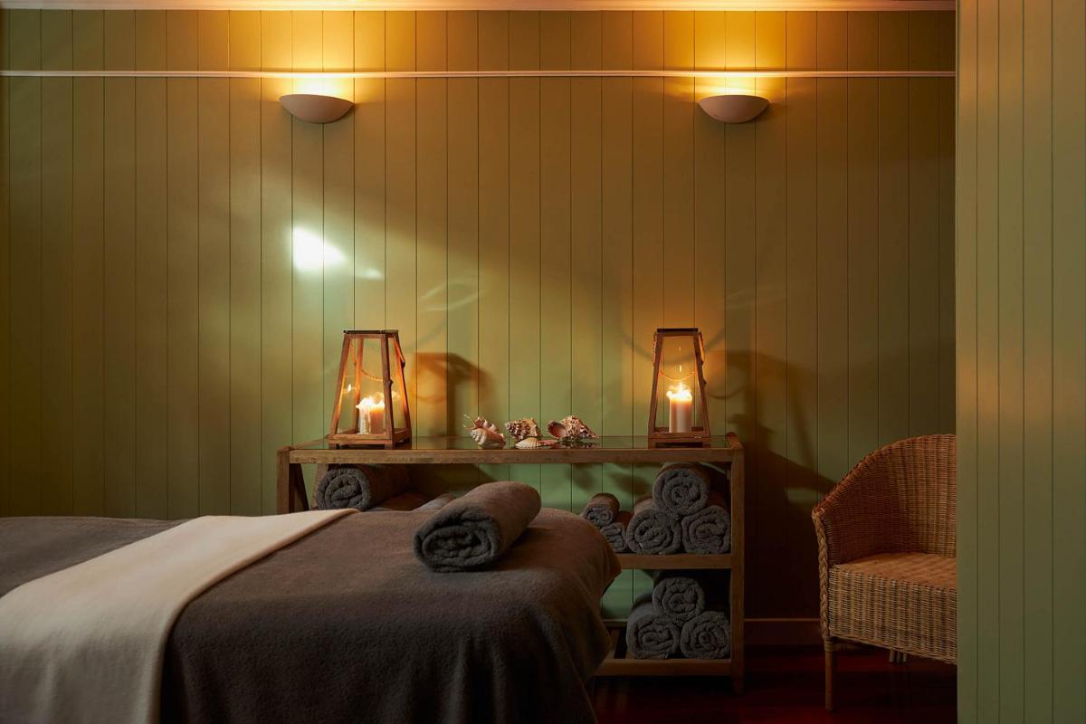 une chambre avec un lit, une chaise et des lumières dans l'établissement Le Grand Hotel des Bains & Spa - Bretagne, à Locquirec
