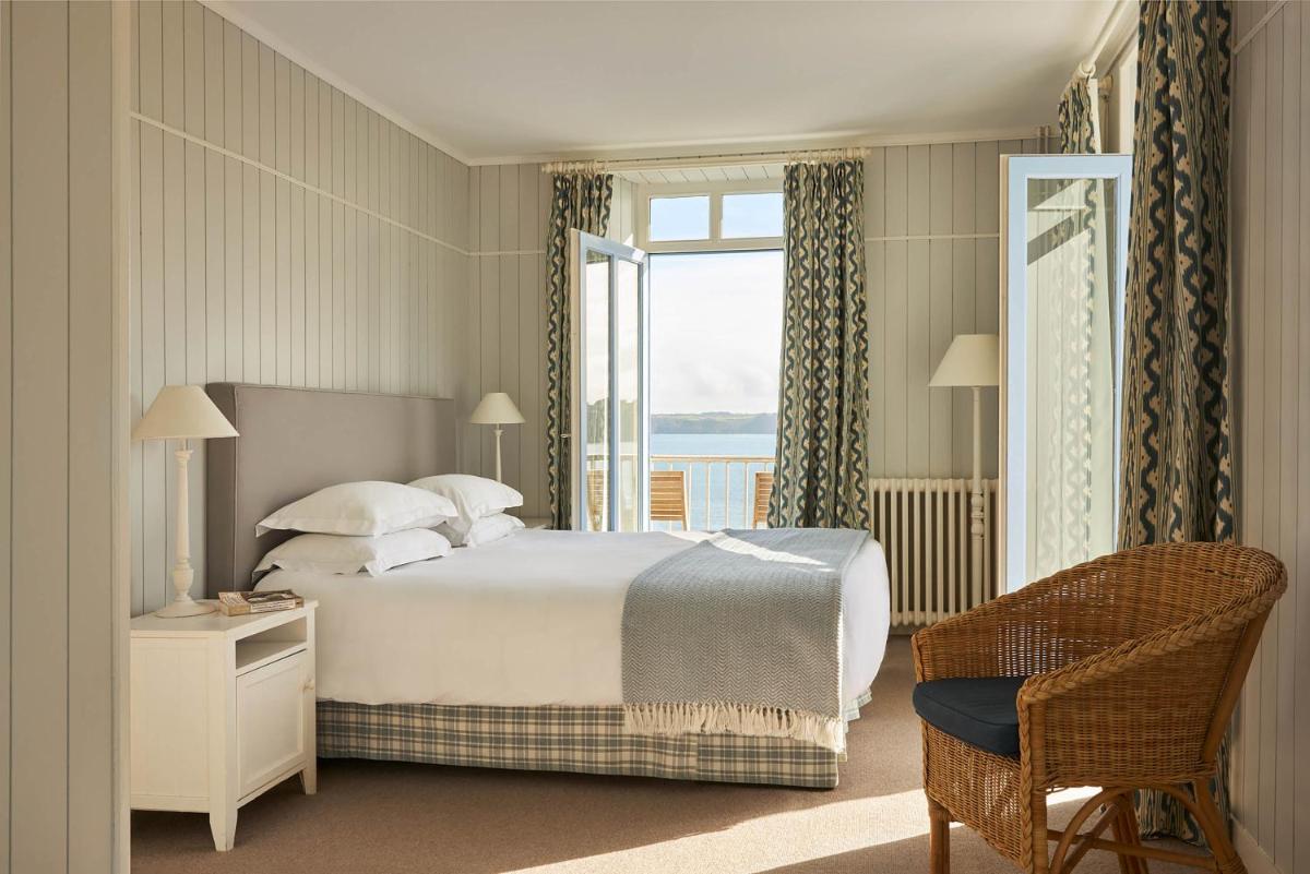 une chambre avec un lit, une fenêtre et une chaise dans l'établissement Le Grand Hotel des Bains & Spa - Bretagne, à Locquirec