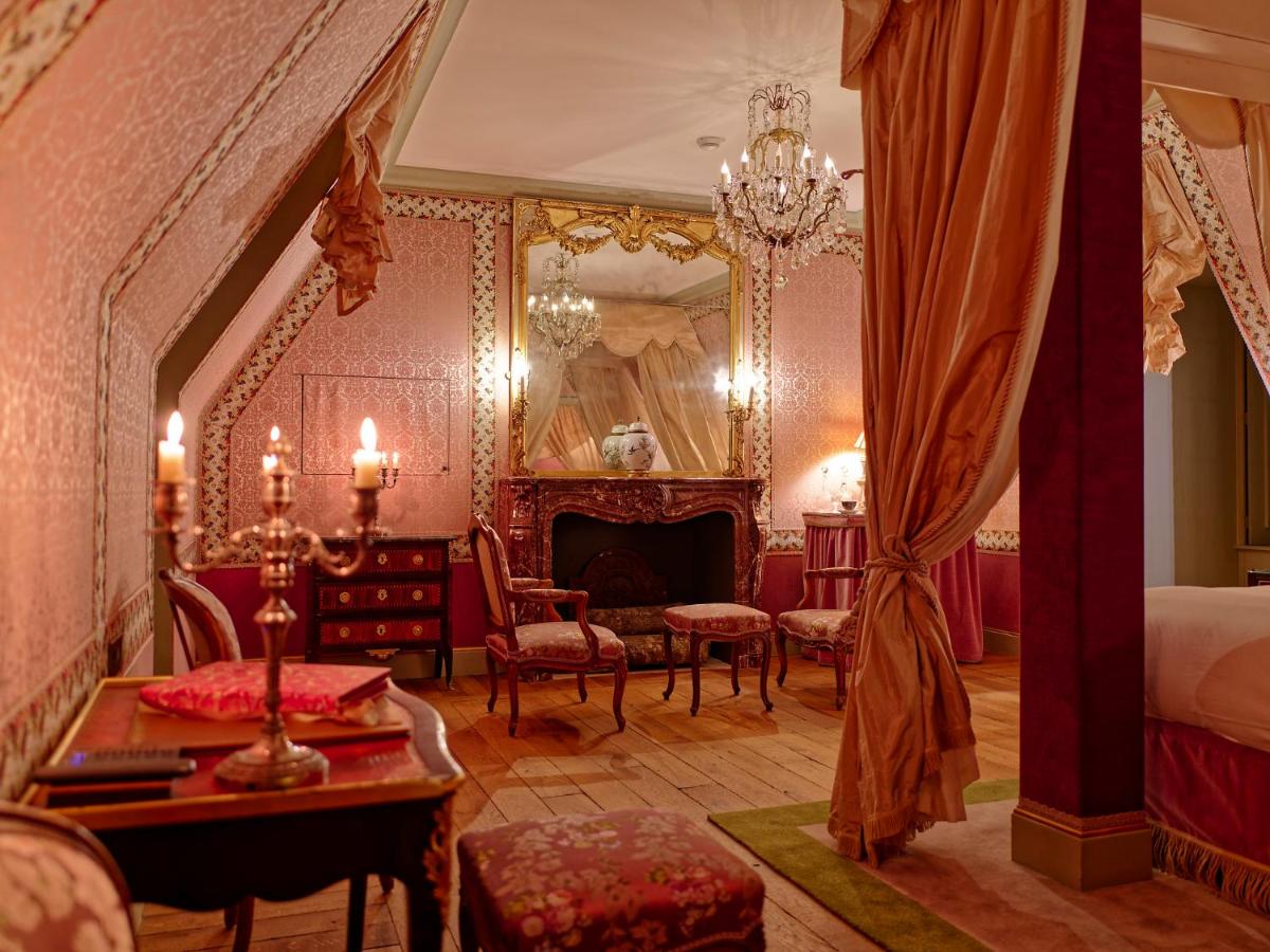une chambre avec un lit et un lustre dans l'établissement Relais & Château Louise de La Vallière, à Reugny