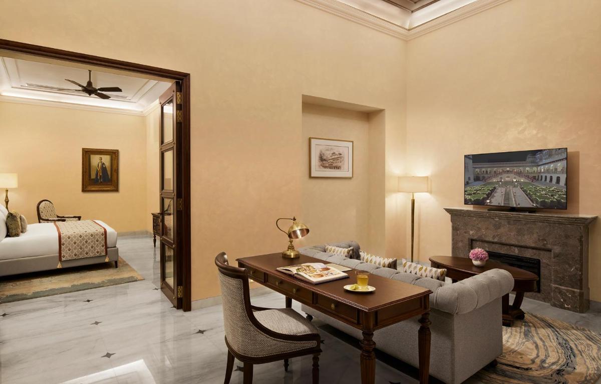 a living room with a couch and a table and a bed at Sawai Man Mahal in Jaipur