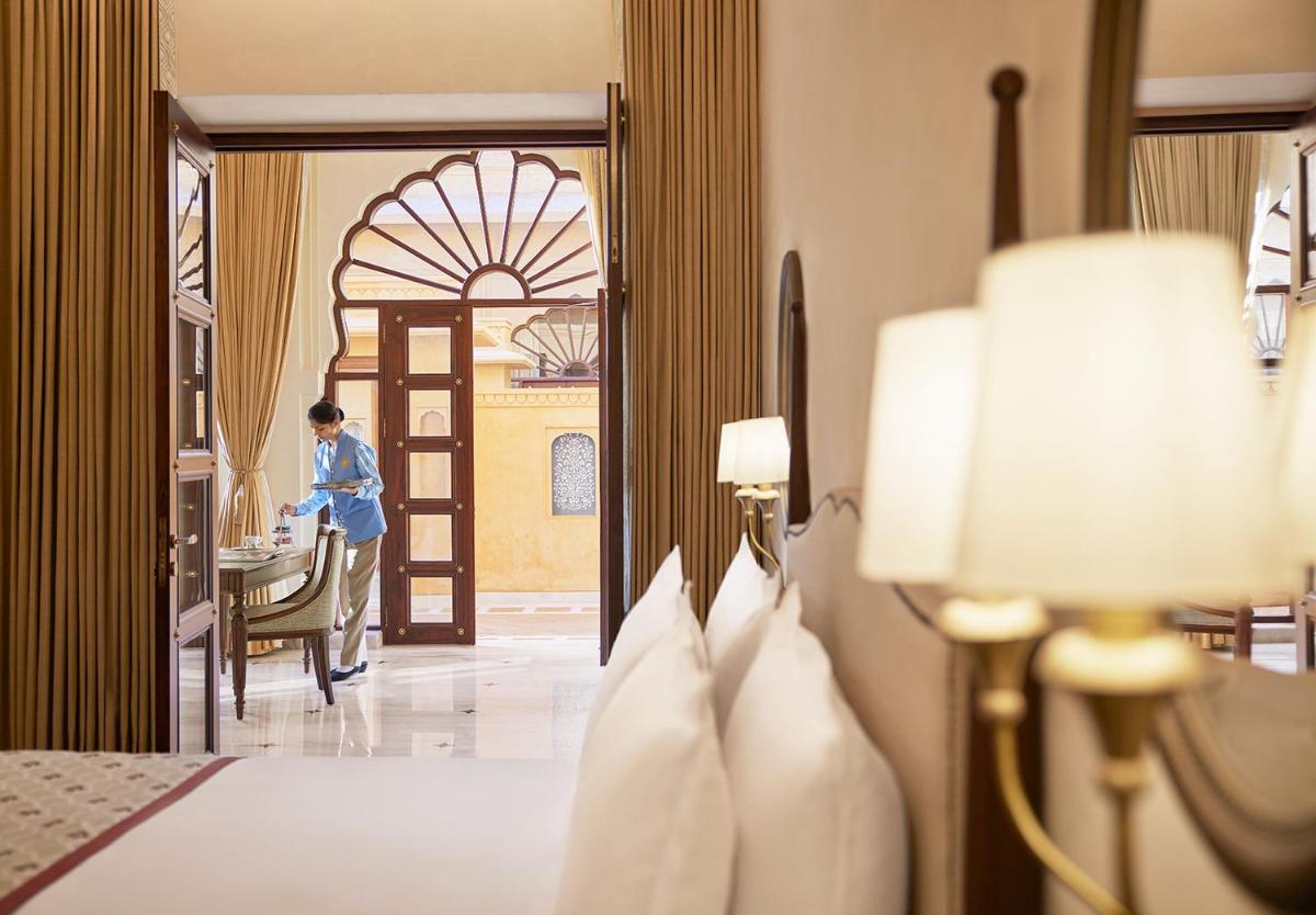 a person standing at a table in a hotel room at Sawai Man Mahal in Jaipur