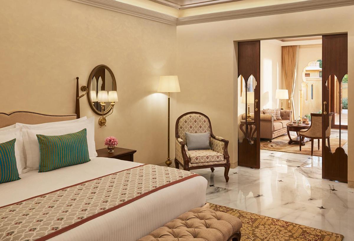 a bedroom with a bed and a living room at Sawai Man Mahal in Jaipur