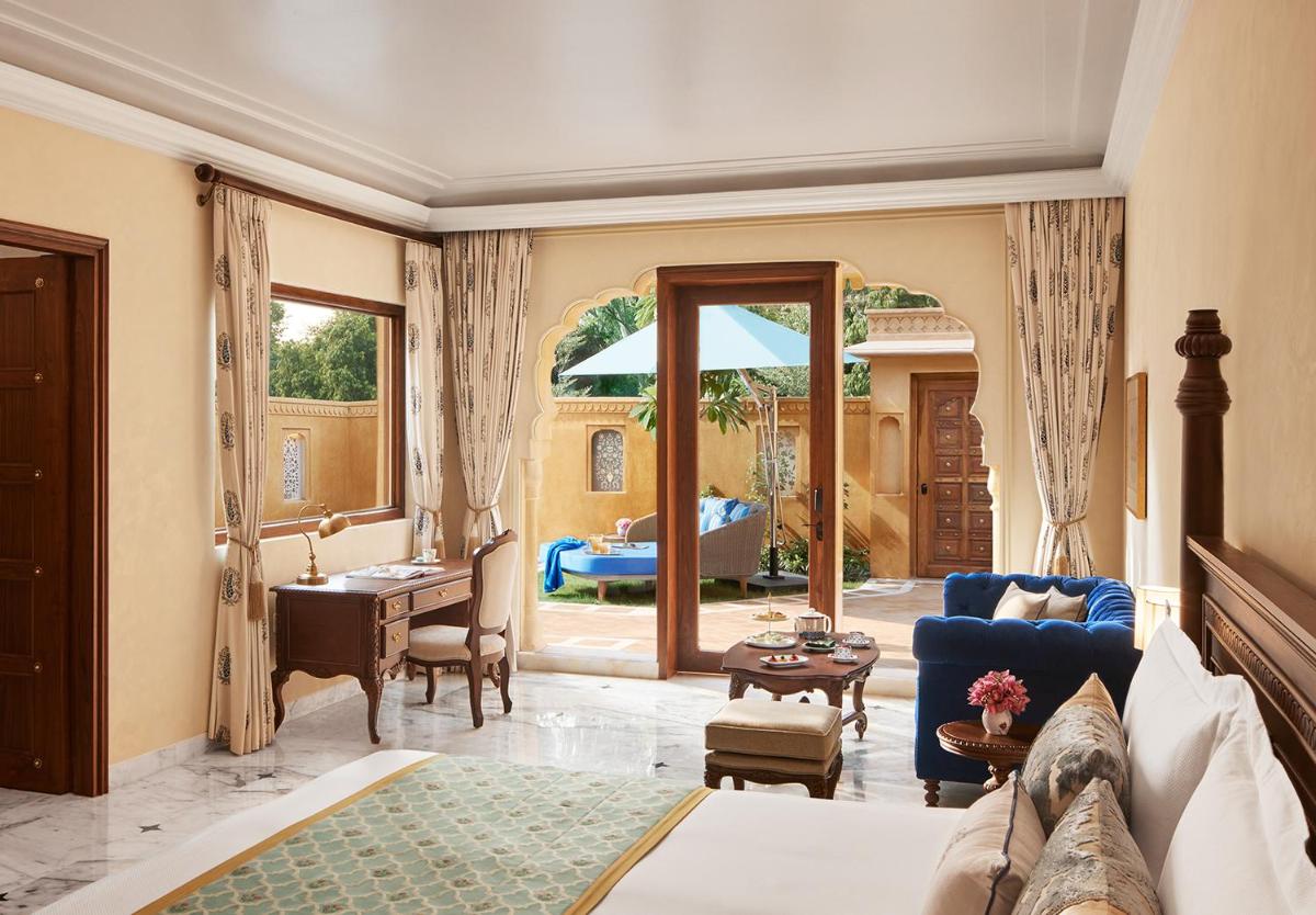a bedroom with a bed and a living room at Sawai Man Mahal in Jaipur