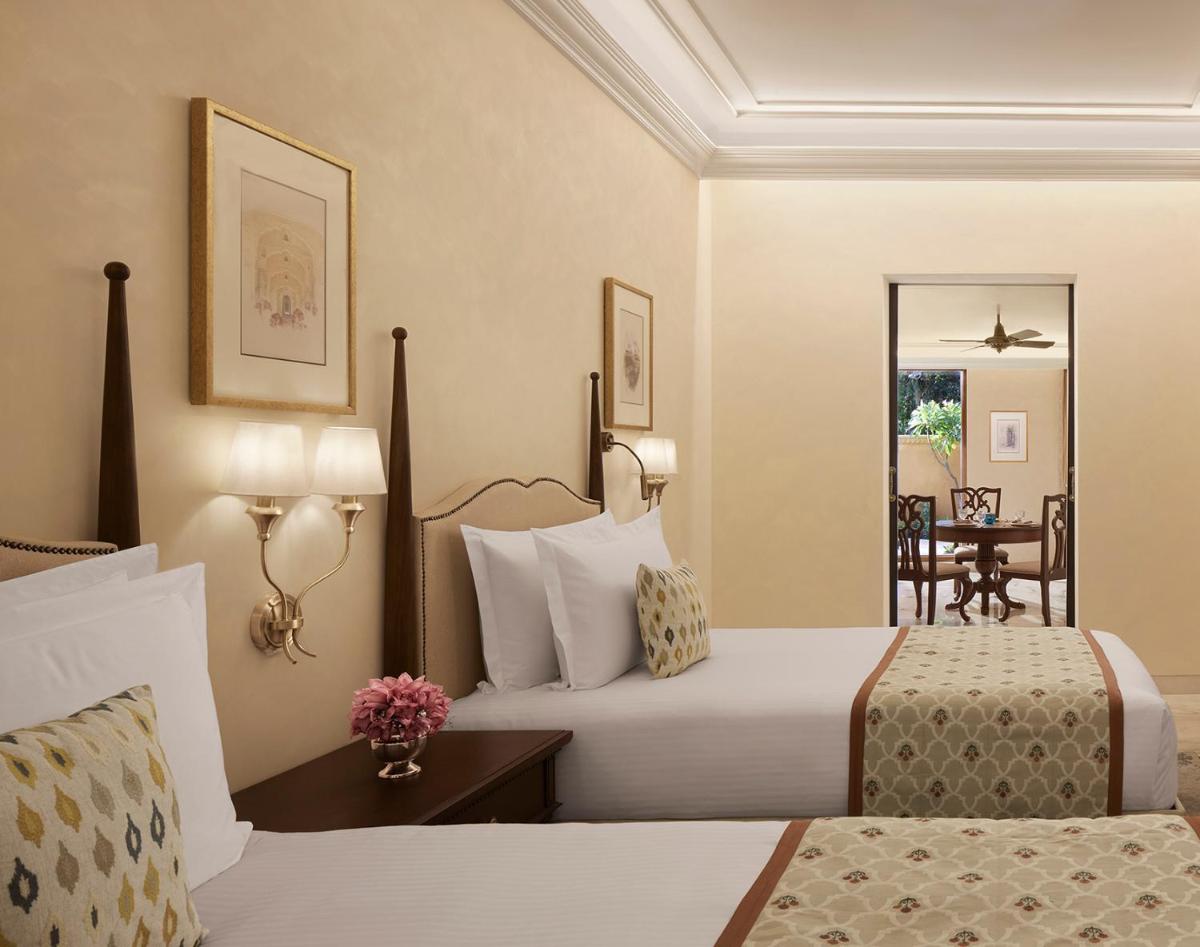 a hotel room with two beds and a table at Sawai Man Mahal in Jaipur