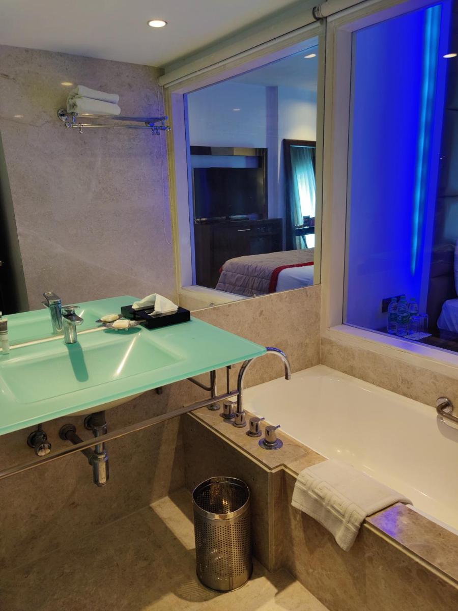 a bathroom with a sink and a bath tub at Hotel Royal Orchid Bangalore in Bengaluru