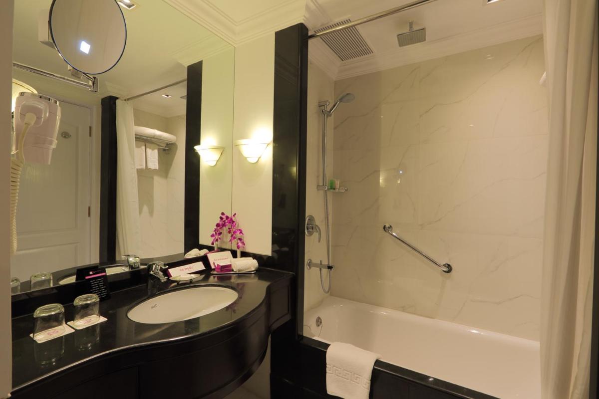 a bathroom with a sink and a shower and a tub at Hotel Royal Orchid Bangalore in Bengaluru
