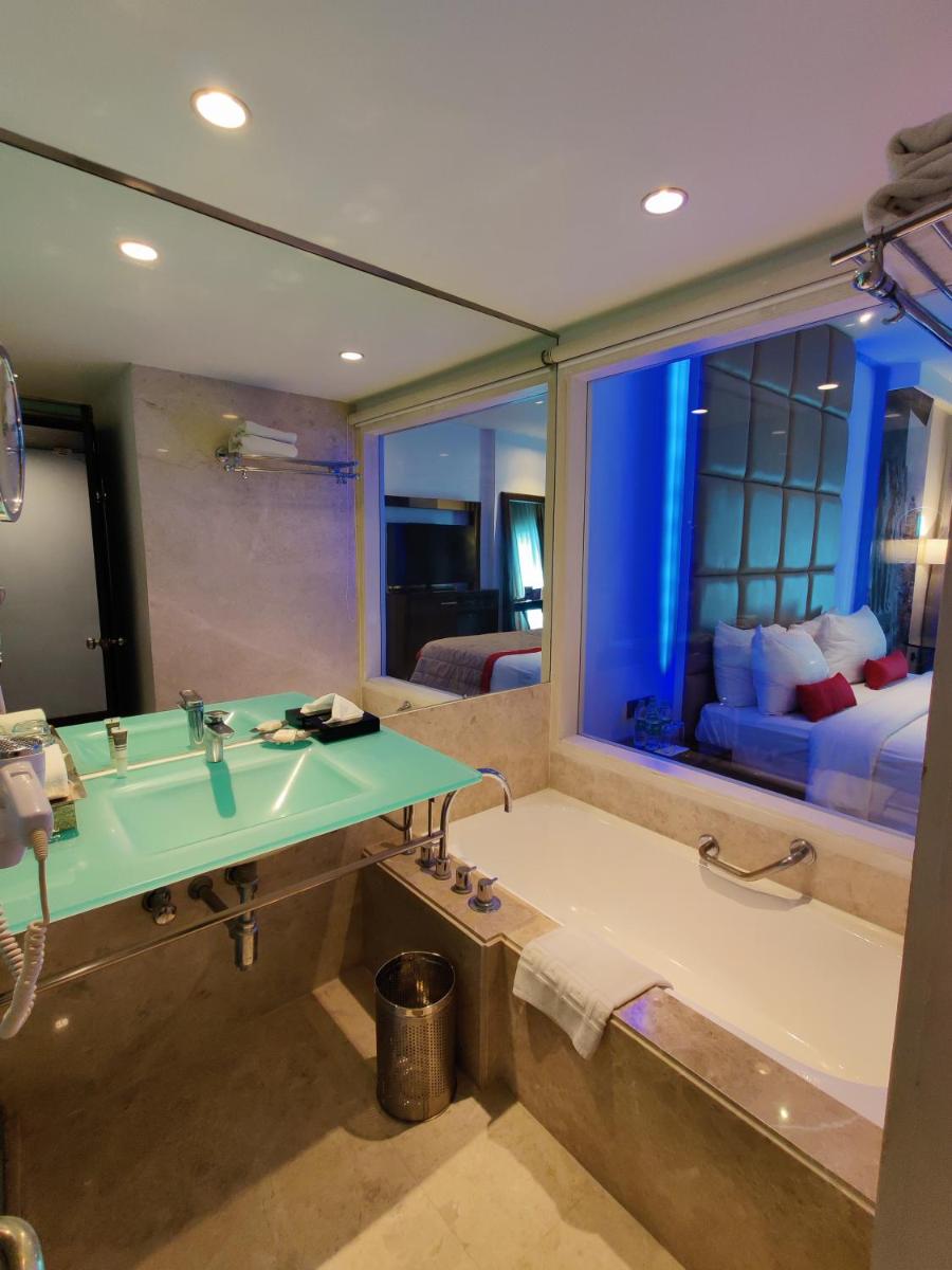a bathroom with a large tub and a large window at Hotel Royal Orchid Bangalore in Bengaluru