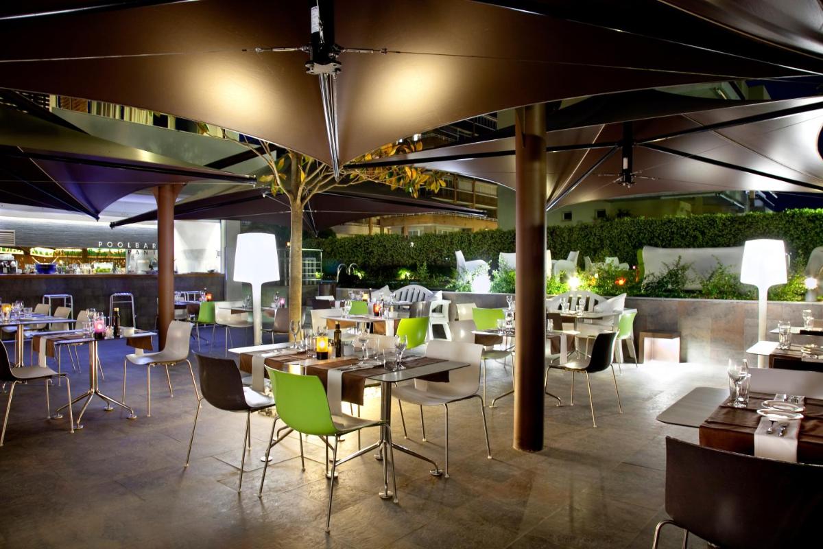 un comedor con mesas y sillas en Magnolia Hotel - Adults Only, en Salou