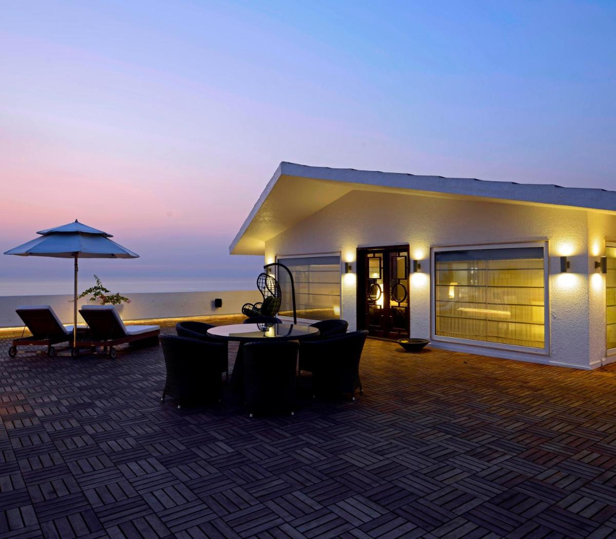 a building with a table and chairs and an umbrella at Sun-n-Sand Mumbai Juhu Beach in Mumbai