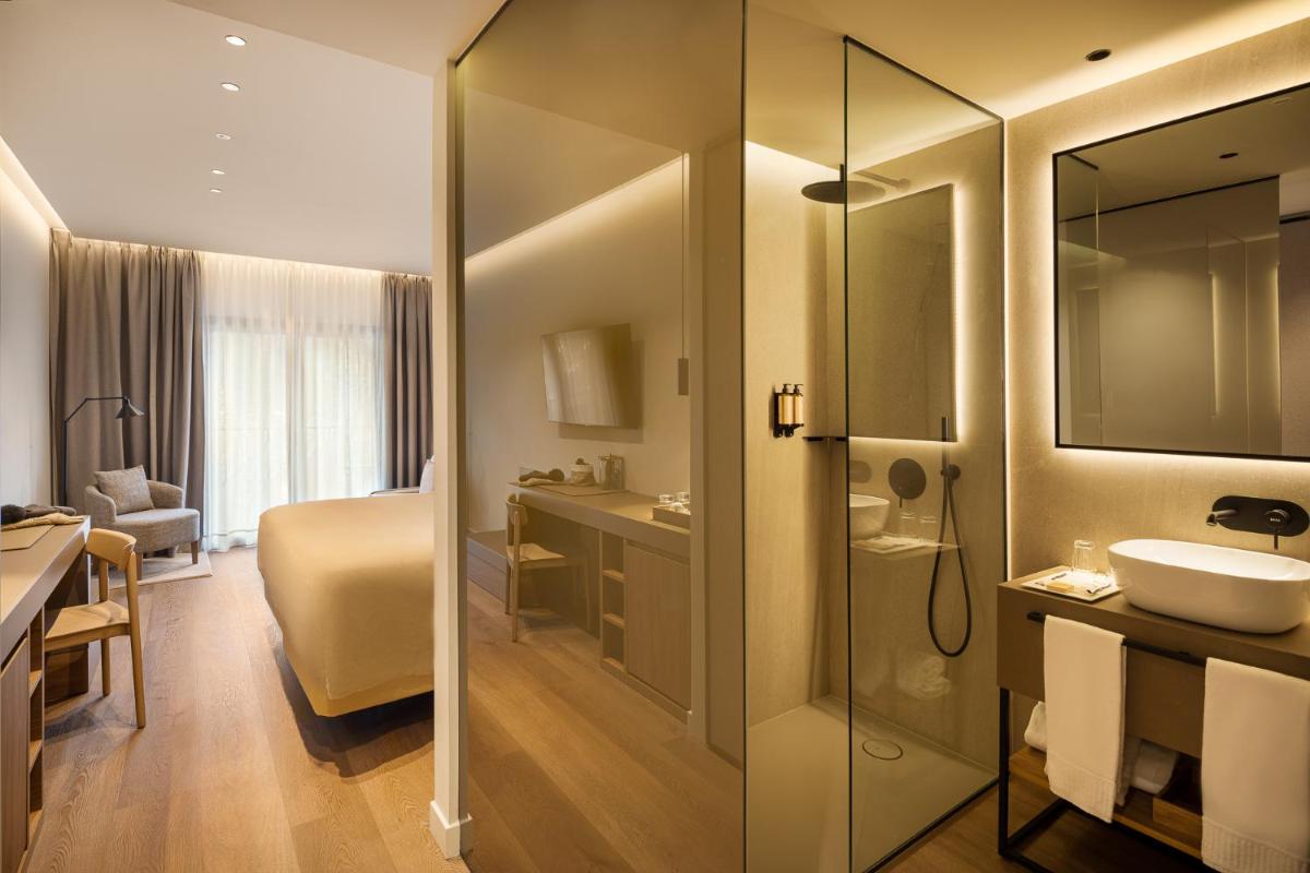 Un baño con inodoro, lavabo y espejo. en Hotel MIM Baqueira Luxury & SPA, en Baqueira Beret