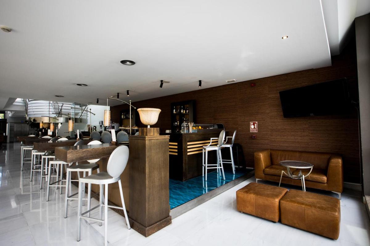 un bar en un restaurante con un montón de taburetes en Pazo Los Escudos Hotel Spa & Resort, en Vigo